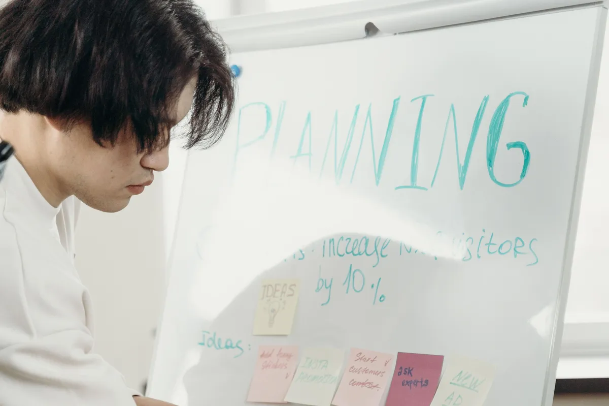 An engineering manager arranging sticky notes on a planning whiteboard